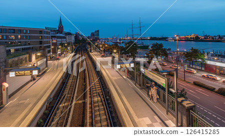 Aerial day to night timelapse of trains arriving at Landungsbrucken station in Hamburg, Germany. Aerial day to night timelapse of trains arriving at Landungsbrucken station in Hamburg, Germany. 126415285