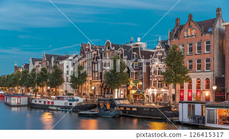 Panoramic timelapse hyperlapse of the illuminated famous Dancing Houses along the Amstel River day to night transition. Amsterdam, Netherlands 126415317