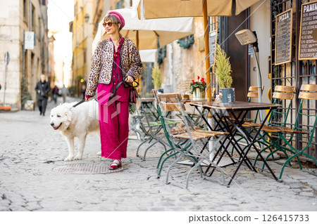 Woman walking dog on Roman street Woman walking dog on Roman street 126415733