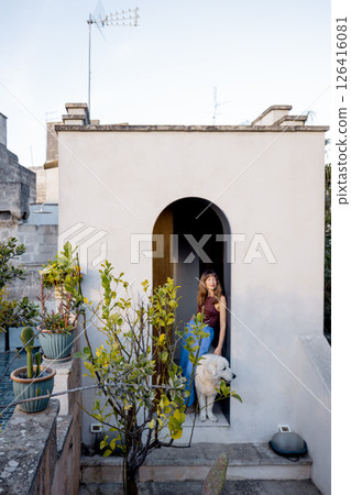 Woman with dog on rustic Mediterranean rooftop entrance Woman with dog on rustic Mediterranean rooftop entrance 126416081