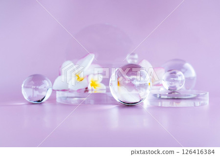 A calming display features aloe serum, centella, glass elements, and flowers for relaxation. 126416384