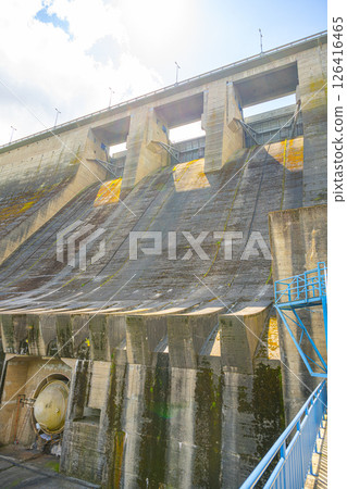 Orlik Dam showcases its massive concrete structure under the sky with water flow visible from the hydroelectric power station. Orlik Dam showcases its massive concrete structure under the sky with water flow visible from the hydroelectric power station. 126416465