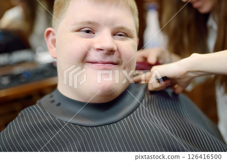 Portrait of a teenager with Down syndrome in a barbershop 126416500