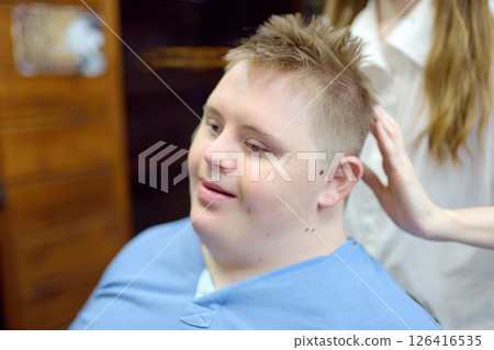 Portrait of a teenager with Down syndrome in a barbershop 126416535