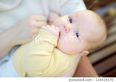 Sweet 2 month old infant lying in mommy's arms Sweet 2 month old infant lying in mommy's arms 126416579