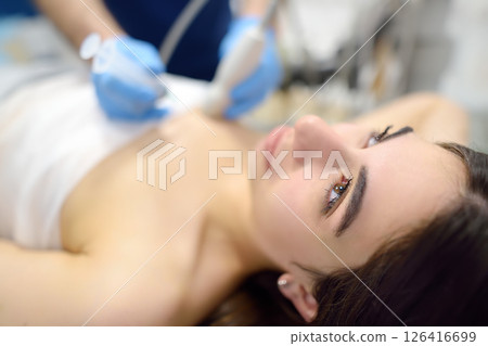 Skillful oncologist puncture of mammary glands of young patient under review ultrasound for diagnosis of breast cancer. 126416699