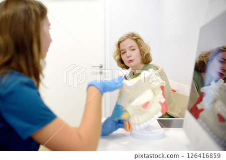 The otolaryngologist explains to the patient about his illness at the appointment. A professional ENT doctor demonstrates a model of the human nose. Treatment of inflammation disease of nose. 126416859