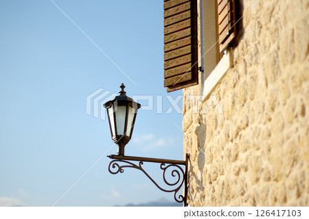 Old lantern on the house wall in Perast, one of the most picturesque towns on the Bay of Kotor. Typical details of an old European coastal town 126417103