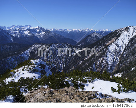 Sweeping mountain vistas showcase snow-covered peaks under a clear blue sky in a remote alpine region Sweeping mountain vistas showcase snow-covered peaks under a clear blue sky in a remote alpine region 126417862