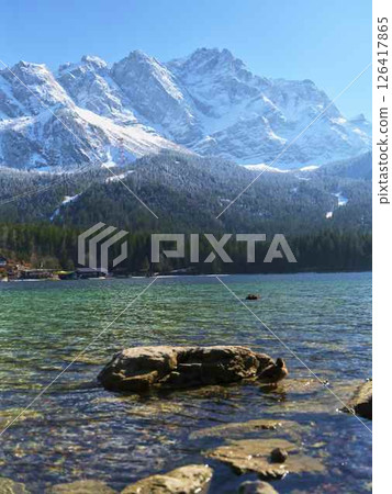 Breathtaking view of snow-capped mountains reflecting in clear blue lake water during sunny day Breathtaking view of snow-capped mountains reflecting in clear blue lake water during sunny day 126417865