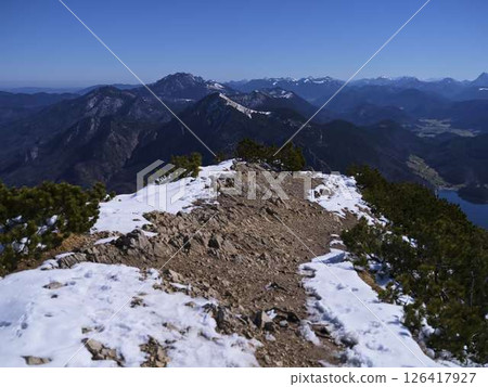 Scenic mountain ridge with snow and expansive views of peaks and valleys during clear daytime Scenic mountain ridge with snow and expansive views of peaks and valleys during clear daytime 126417927