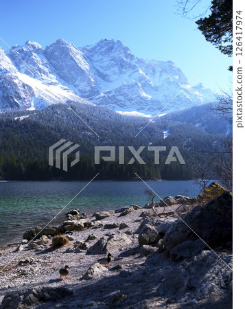 Majestic snow-capped mountains reflect in the tranquil lake during a sunny winter day 126417974