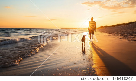 A man and his dog walking on a sandy beach in the setting sun A man and his dog walking on a sandy beach in the setting sun 126418247