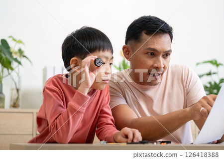 Activity of father and son engaging in hands-on learning with projects Activity of father and son engaging in hands-on learning with projects 126418388