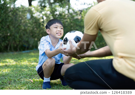 Wellness captured: Happy boy receiving soccer ball from dad 126418389