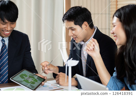 Engaging Discussion on ESG. Team members collaborating on sustainability strategies in a modern office. Engaging Discussion on ESG. Team members collaborating on sustainability strategies in a modern office. 126418391