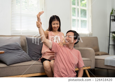 Wellness and Support. Elderly couple exercising together at home. 126418420