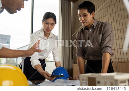 Sustainability engineers analyzing building plans in a collaborative environment Sustainability engineers analyzing building plans in a collaborative environment 126418443