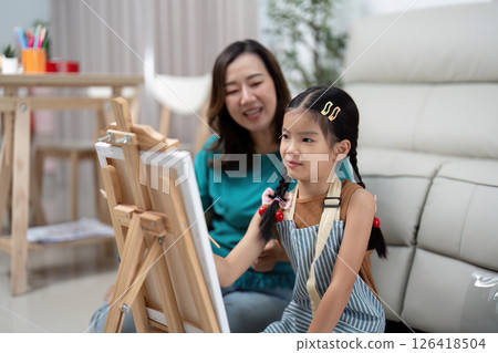 Activity mother and daughter painting together on canvas 126418504