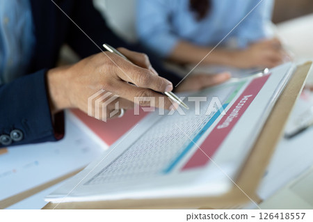 Accounting Review. Business professional analyzing financial data with pen on document. 126418557