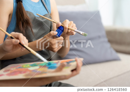 Lesbian couple bonding over a painting activity at home Lesbian couple bonding over a painting activity at home 126418560