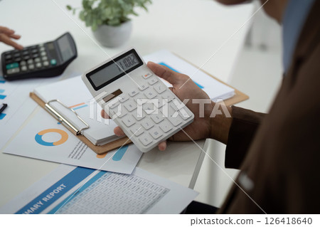 Financial Analysis and Accounting. Professional using calculator to review financial reports. 126418640