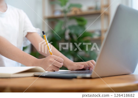Back to School girl writing and using laptop during study time Back to School girl writing and using laptop during study time 126418682