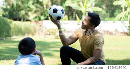 Wellness through playful interaction: Father teaches son soccer skills 126418691