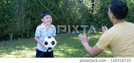 Wellness and happiness: Young boy playing soccer with father Wellness and happiness: Young boy playing soccer with father 126418720