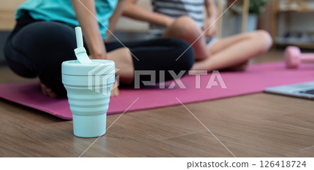 Wellness Hydration: Focus on a water bottle during yoga session Wellness Hydration: Focus on a water bottle during yoga session 126418724