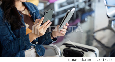 Journey to the airport with traveler checking two smartphones Journey to the airport with traveler checking two smartphones 126418728