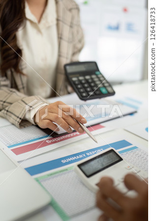 Engaging Financial Discussion. Accountant presenting summary report and calculator to client. 126418733