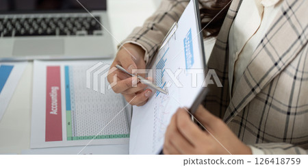 Financial Reporting and Analysis. Business professional reviewing charts and data on clipboard. Financial Reporting and Analysis. Business professional reviewing charts and data on clipboard. 126418759