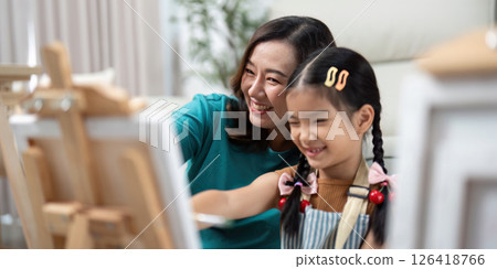 Activity mother and daughter laughing while painting 126418766
