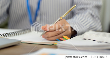 Note-taking and Organization. Business professional writing in a notebook. 126418803