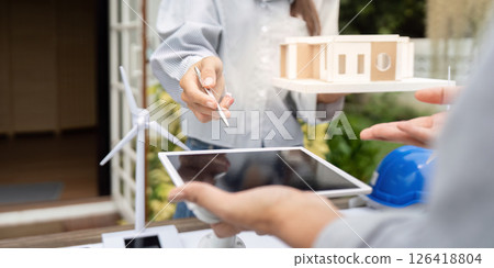 Sustainability engineer collaborating on renewable energy design models 126418804