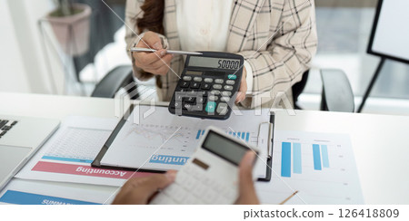 Financial Reporting. Accountant showing calculator display with figures during client meeting. 126418809