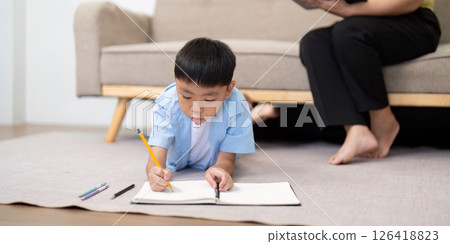 Back to School. Boy focused on writing in notebook at home. 126418823
