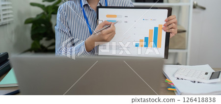 Data Presentation. Business professional analyzing charts during a video meeting. Data Presentation. Business professional analyzing charts during a video meeting. 126418838