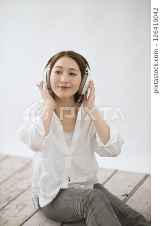 Young woman listening to music on headphones Young woman listening to music on headphones 126419042