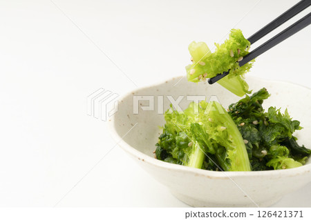 用筷子夾起剛採摘的略醃山葵葉 用筷子夾起剛採摘的略醃山葵葉 126421371