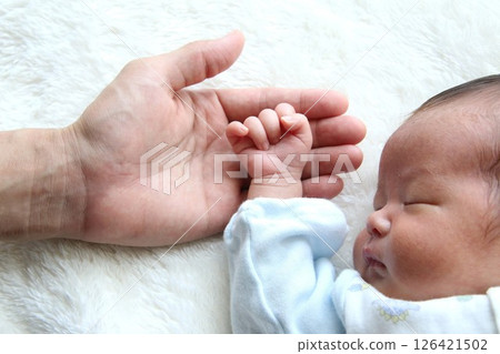 Daddy's hand and sleeping newborn baby 126421502