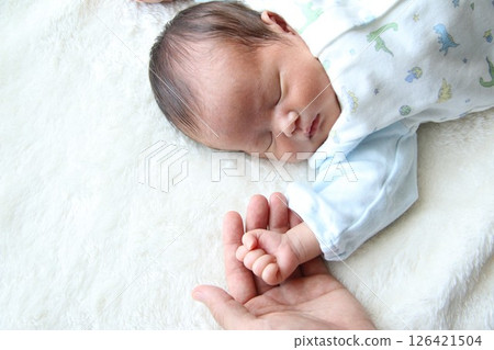 Daddy's hand and sleeping newborn baby Daddy's hand and sleeping newborn baby 126421504