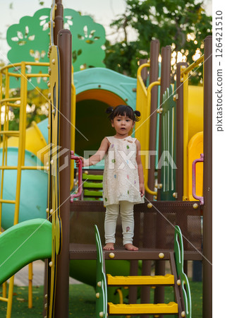 happy toddler girl playing at a outdoor playground in park happy toddler girl playing at a outdoor playground in park 126421510