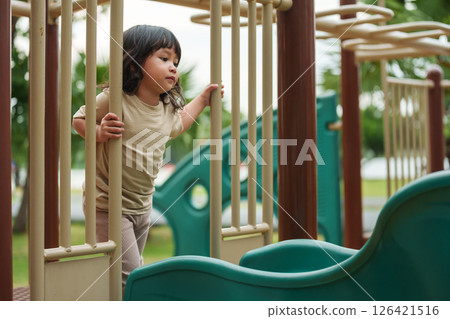 happy toddler girl playing at a outdoor playground in park happy toddler girl playing at a outdoor playground in park 126421516