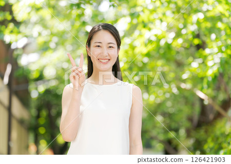 一名女子在公園裡做出和平手勢 126421903