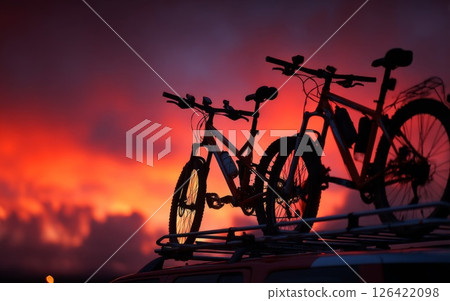 Two Mountain Bikes on Car Roof at Sunset 126422098