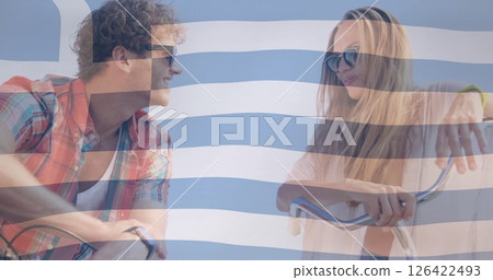 Greek flag image over smiling couple riding bicycles 126422493