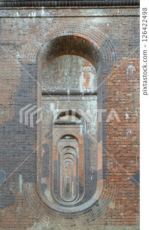 he semi-circular arches vaulting supporting traditional red brick piers with smooth limestone. 126422498
