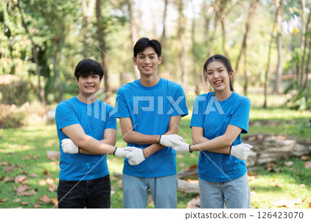 Community and Collaboration. Three smiling volunteers posing together after a successful park cleanup, fostering relationships through environmental action. Community and Collaboration. Three smiling volunteers posing together after a successful park cleanup, fostering relationships through environmental action. 126423070